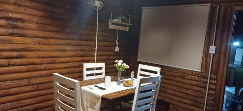 a dining room with a wooden wall and a table and chairs at El mariscal in Gardey