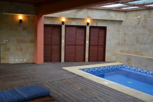 a pool in a house with a wooden deck and a swimming pool at Finca Paraiso Mountain Retreat near San Jose Airport in Birrí