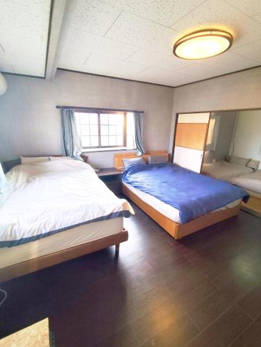 a bedroom with two beds and a mirror at ビーチ コンビニ 温泉徒歩4分以内 BBQ無料 12人OK 5LDK戸建貸切宿 White sun villa in Shirako
