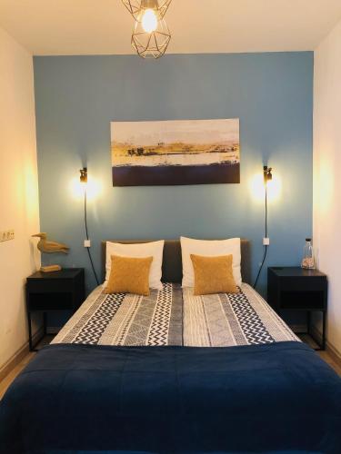 a bedroom with a bed with two lamps and a painting at Tales Of Us Terrace in Aveiro