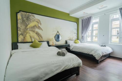 a bedroom with two beds and a large painting on the wall at Elva Shine Dalat Hotel in Da Lat