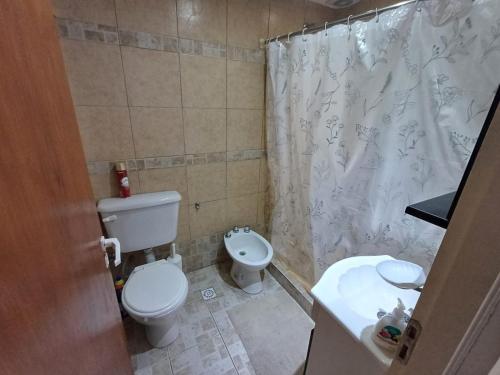 a bathroom with a toilet and a shower curtain at Depto Costa in San Bernardo