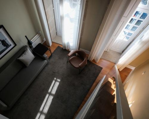 une vue aérienne d'un salon avec un canapé et une chaise dans l'établissement Casa do Juncal, à Guimarães