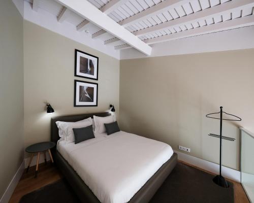 - une chambre avec un lit blanc et un plafond blanc dans l'établissement Casa do Juncal, à Guimarães