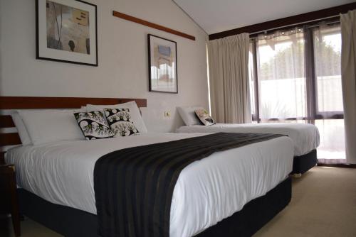 a hotel room with two beds and a window at The Apple Inn in Batlow