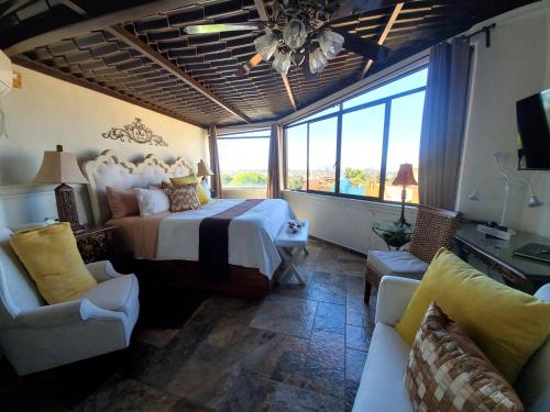 a bedroom with a large bed and a large window at Casa Grande Luxury Boutique Hotel in San Miguel de Allende