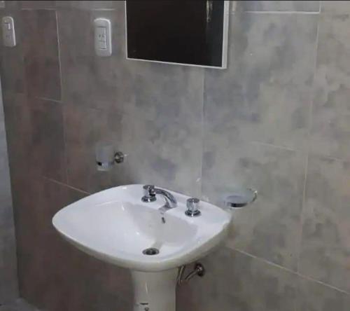 un bagno con un lavandino bianco e uno specchio di Benjamín Relax a Victoria