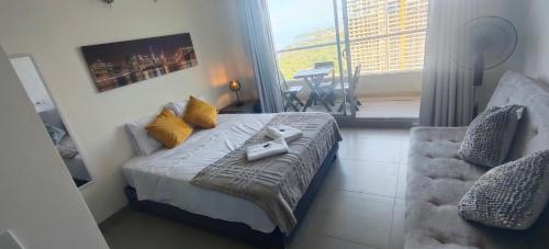 a bedroom with a bed with a chair and a window at Santa marina in Santa Marta