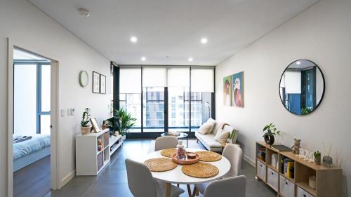 a living room with a table and chairs and a couch at Modern 2BR Apartment in Sydney Olympic Park in Sydney