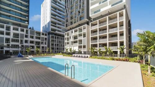 a swimming pool in front of a large building at Modern 2BR Apartment in Sydney Olympic Park in Sydney