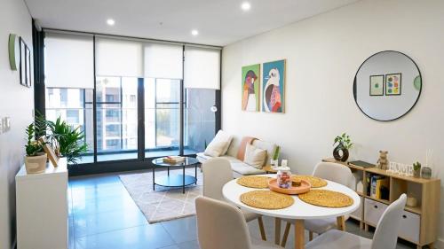 a living room with a table and chairs at Modern 2BR Apartment in Sydney Olympic Park in Sydney