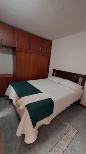 a bedroom with a large bed with wooden cabinets at Hotel Hierbabuena y Restaurante in Pasto