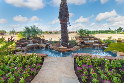 a garden with two ponds and a palm tree and flowers at Econo Lodge Inn & Suites Houston NW-Cy-Fair in Houston