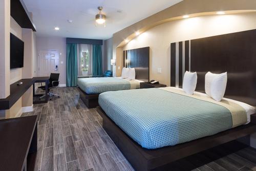 a hotel room with two beds and a desk at Econo Lodge Inn & Suites Houston NW-Cy-Fair in Houston