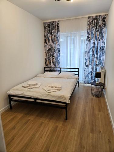a bedroom with a bed and a wooden floor at Apartament Dobra Nocka 2 in Przeworsk