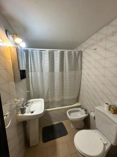 a white bathroom with a toilet and a sink at Espacio necochea in Mendoza
