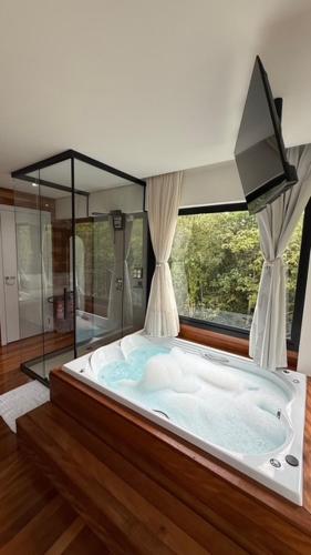 eine große Badewanne in einem Zimmer mit Fenster in der Unterkunft Cabanas do Platô in Praia Grande