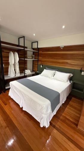 ein Schlafzimmer mit einem großen Bett und Holzböden in der Unterkunft Cabanas do Platô in Praia Grande
