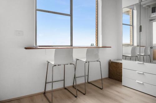 eine Küche mit drei Barhockern und einem Fenster in der Unterkunft Bondi Beach Studio with an ocean view in Sydney