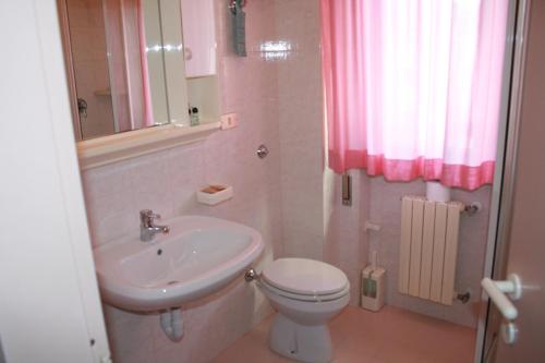 y baño con aseo blanco y lavamanos. en La Perla B&B Hotel, en Roseto degli Abruzzi