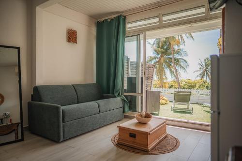a living room with a couch and a large window at Le M Hotel Marie Galante in Beauregard