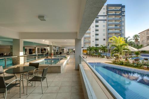Een afbeelding van het zwembad van een hotel met tafels en stoelen. bij Apartamento por Temporada Veredas Flat - Rio Quente Goias in Rio Quente