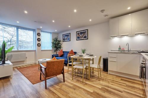 a kitchen and living room with a table and chairs at Luxuriously Cosy 1 Bed Flat at Trinity Point Gravesend, Suitable for Long Stay and Short Stay in Gravesend