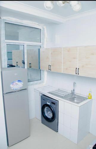 a kitchen with a washing machine and a sink at Charming apartment limete 1ere rue Kinshasa in Kinshasa