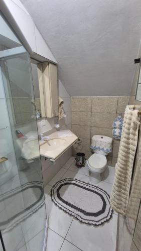 ein Badezimmer mit Dusche, Toilette und Waschbecken in der Unterkunft Casa completa a 10min da praia de BC in Balneário Camboriú