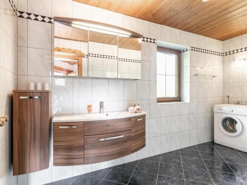a bathroom with a sink and a washing machine at Almruhe Alpbach in Alpbach