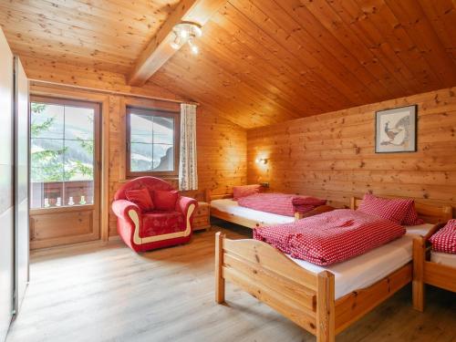 a log cabin with two beds and a chair at Almruhe Alpbach in Alpbach