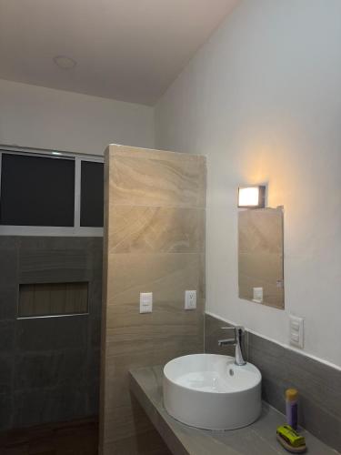 a bathroom with a sink and a mirror at Hotel Mochomos Huajuapan in Huajuapan de León