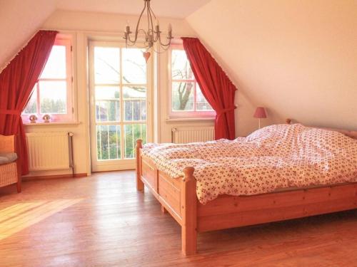 een slaapkamer met een bed en ramen in een kamer bij Romantic half-timbered house in Egestorf