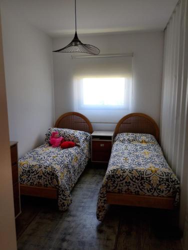 two beds in a small room with a window at La Pausa Container House in Manantiales