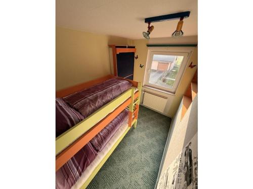 zwei Betten in einem kleinen Zimmer mit Fenster in der Unterkunft Holiday apartment with 2 bedrooms in Hoffelde