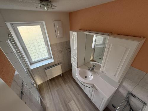 ein weißes Badezimmer mit Waschbecken und Fenster in der Unterkunft Holiday apartment with 2 bedrooms in Hoffelde