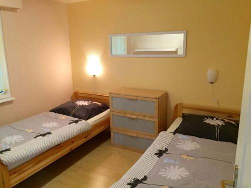 ein Schlafzimmer mit zwei Betten und einer Kommode in der Unterkunft 1 - Anett Pollok in Neuruppin