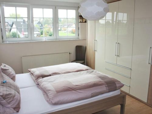 ein Schlafzimmer mit einem Bett und einem Fenster in der Unterkunft Holiday apartment with 3 bedrooms in Kördorf