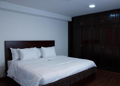 una camera da letto con un grande letto bianco e armadi neri di Tikva Hotel a Cuenca