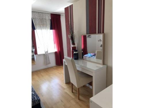 een wit bureau met een stoel en een spiegel bij House 4seasons Scharbeutz in Scharbeutz