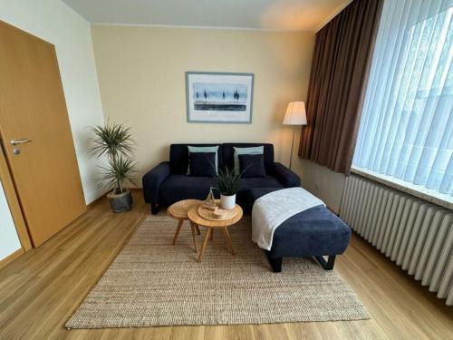 un salon avec un canapé bleu et une table dans l'établissement North Beach Pearl 2, à Norderney