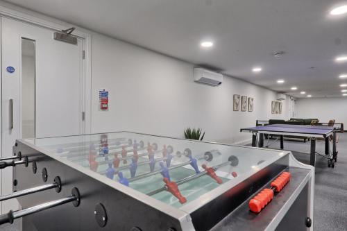 a ping pong table in a room with ping pong balls at Homely & Lush 1 Bed Apartment at Trinity Point Gravesend, Suitable for Long Stay and Short Stay in Gravesend