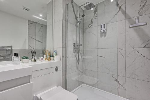 a white bathroom with a shower and a toilet at Homely & Lush 1 Bed Apartment at Trinity Point Gravesend, Suitable for Long Stay and Short Stay in Gravesend