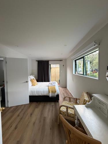 een slaapkamer met een bed, een bank en een raam bij The Hut in Russell