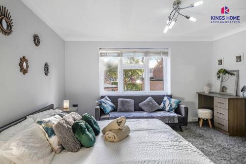 een slaapkamer met een bed en een bank bij 4 BR 6 Beds 3 Bath PS4, Pool Table Parking x4 Close to Legoland & Windsor in Maidenhead