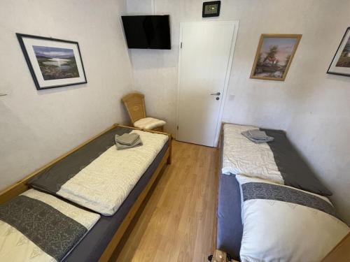 2 Betten in einem kleinen Zimmer mit einem TV in der Unterkunft Dahlke with fireplace and sauna in Kleinweidelbach