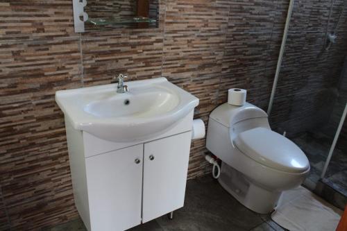 een badkamer met een wastafel en een toilet bij Mallki bungalows with pool in Vichayito