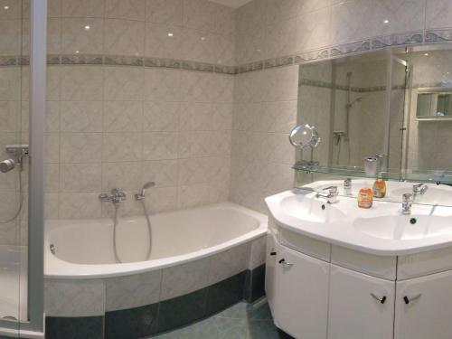 een badkamer met een bad en een wastafel en een ligbad bij Holiday apartment with 2 bedrooms in Bergholz