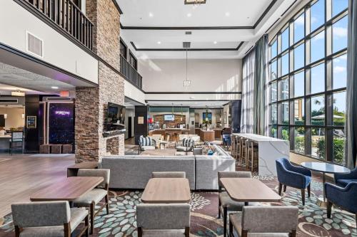 a lobby with tables and chairs in a building at Staybridge Suites Houston-NASA Clear Lake by IHG in Webster