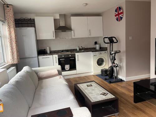 een woonkamer met een bank en een keuken bij One Bedroom Flat in London Heathrow 20 minutes drive in Greenford